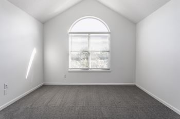 A room with a window and a carpeted floor